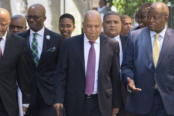 Pravin Gordhan walks with members of the Finance Ministry